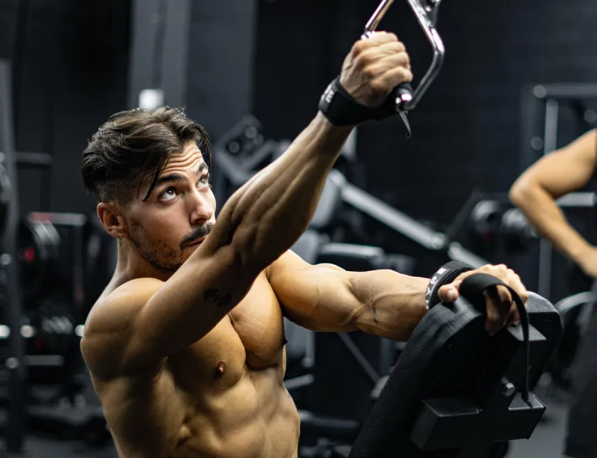 Entrenador personal online Patxi Fitness entrenando con polea en un gimnasio de alta calidad. Inspira el cambio físico y la definición muscular que puedes lograr con sus planes de entrenamiento.